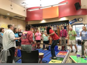 Instructor leading a group of adults in a music training event.