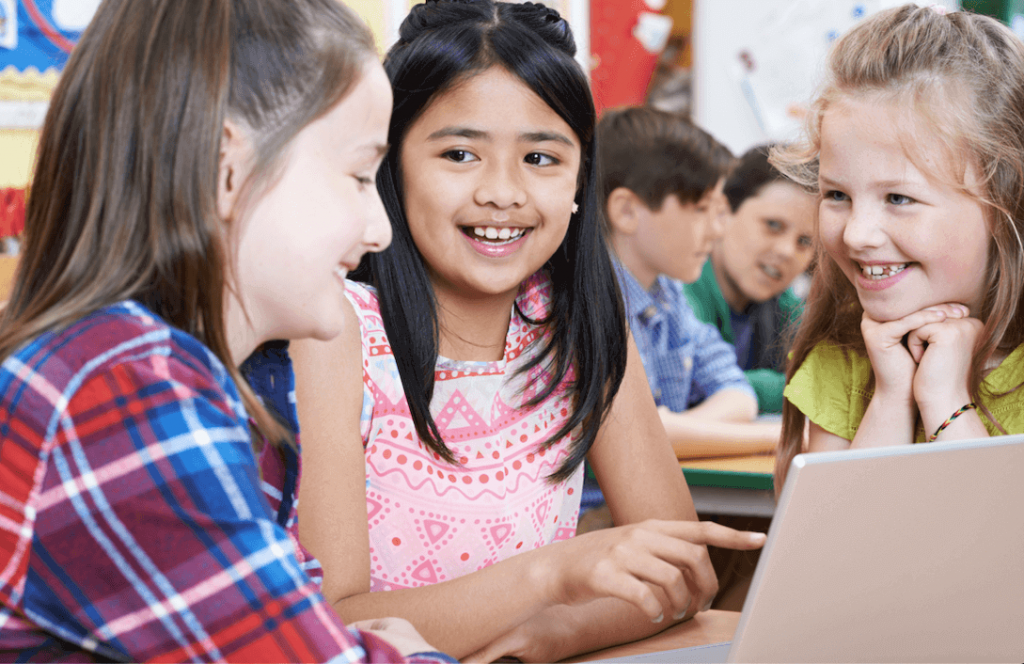 Image of three female students gathered around a device