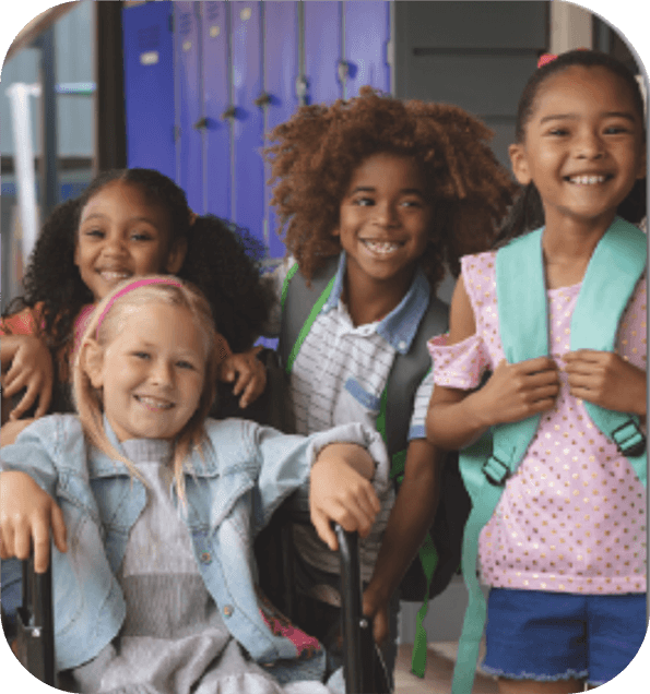 Una imagen de cuatro niños pequeños sonriendo en el pasillo de la escuela que representa el tema Bienvenido a Pre-K de Quaver Pre-K