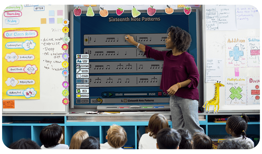 OurTechnology – QuaverEd Teacher stands in front of a Smart board teaching a Sixteenth Note Patterns activity in front of students