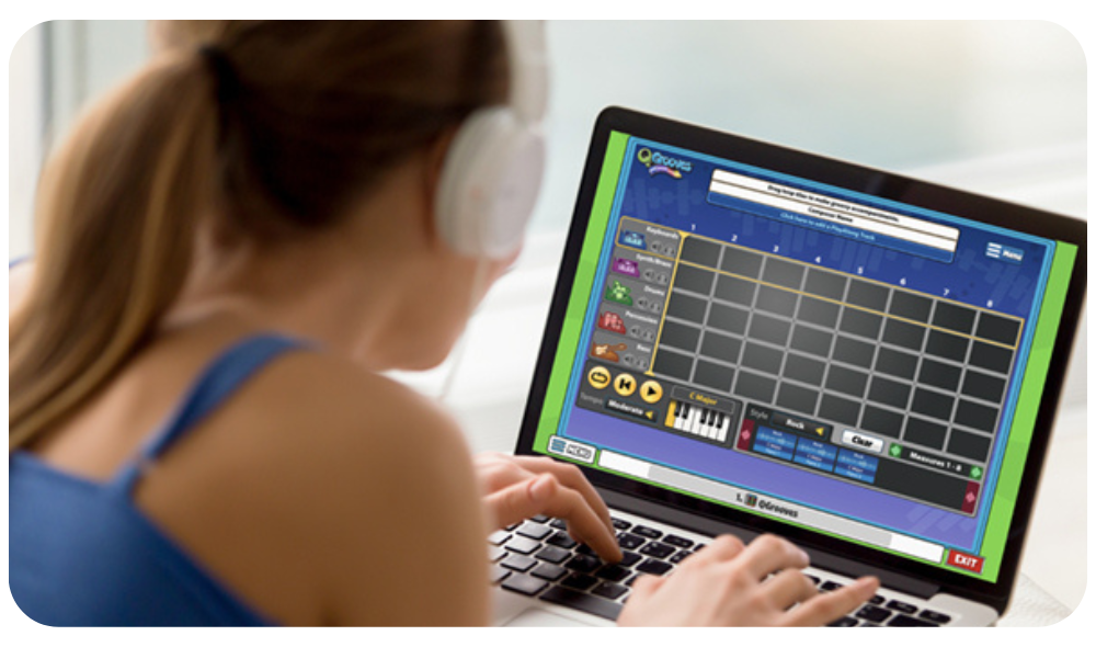 Website-Rounded-Corner-6 – QuaverEd Student with headphones using a laptop with QuaverEd's QGrooves Composition Tool.