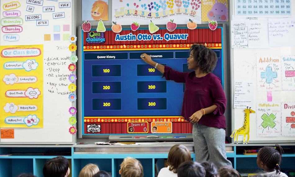 An elementary school teacher using Quaver Music games on a smartboard to teach her students