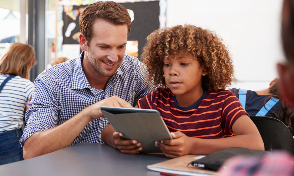 Music teacher showing a young student how to use Quaver Music on a tablet