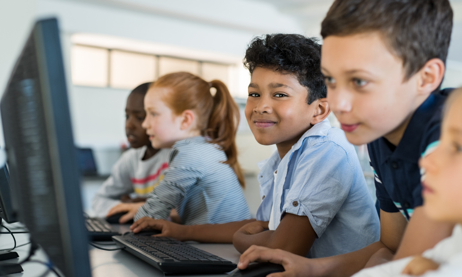 smiling children using QuaverMusic on their computers