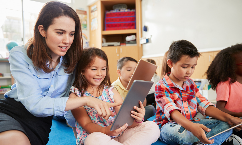 A teacher showing young students Quaver Music on their tablets