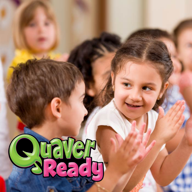 A little girl and boy looking at each other and smiling while clapping along to Quaver Ready songs