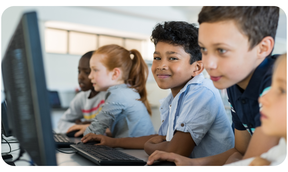 Happy QuaverEd students – QuaverEd Students smiling while on their computers