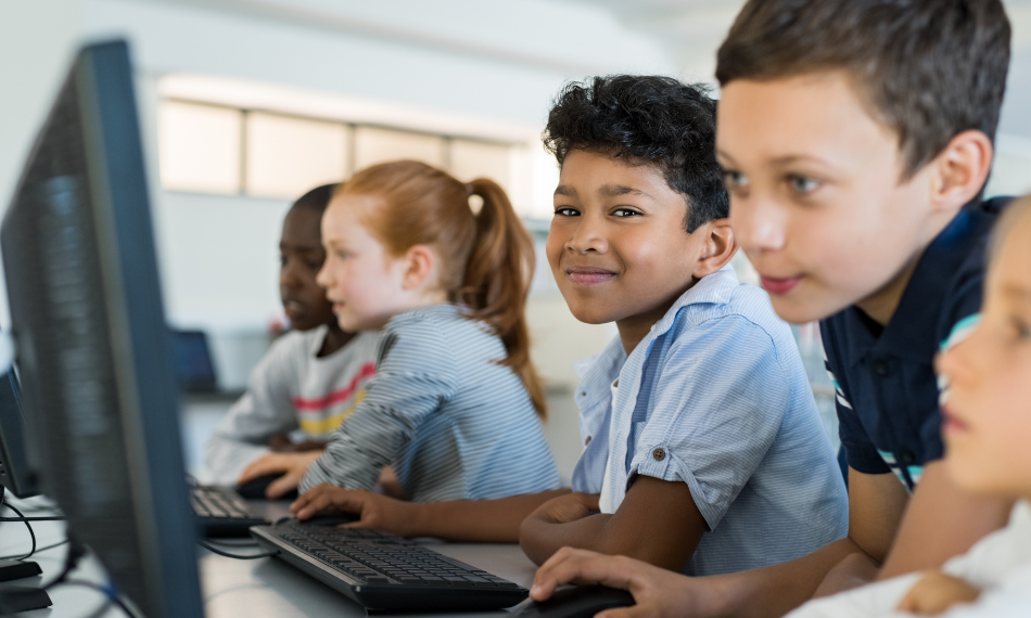 Students smiling while using Quaver Ed on their computers