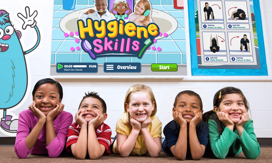 Children smiling in a classroom with a Quaver Health PE hygiene skills video on a smart board behind them